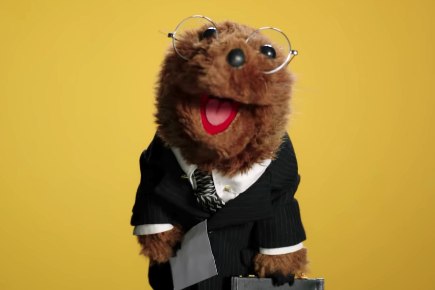 Joe the Legal weasel, a Muppet weasel wearing glasses and a suit and carrying a briefcase