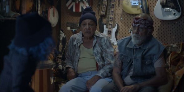 Cheech and Chong in a basement surrounded by guitars