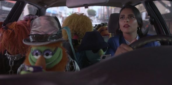 The members of the Electric Mayhem are in Nora's car, looking at their phones. Nora is driving.