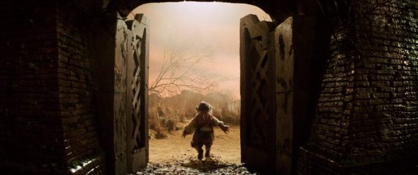 Screenshot from Labyrinth: Hoggle exits the labyrinth in a huff waving the doors shut behind him.