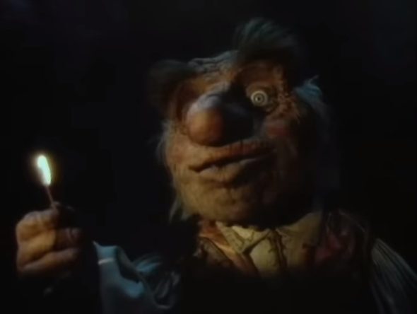 Screenshot from the music video for "Underground": Hoggle holds up a lighted match in the darkness.