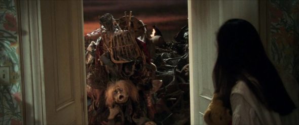 Screenshot from Labyrinth: The Junk Lady appears on the other side of Sarah's door.