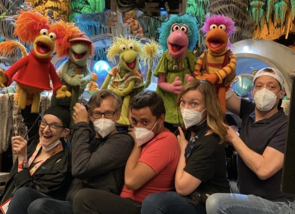 The puppeteers of the Fraggle Five, all wearing masks, with their characters on the set of 'Back to the Rock'.