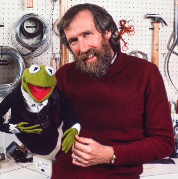 Jim Henson and Kermit standing in front of a workbench with electrical tape and a hammer and such.