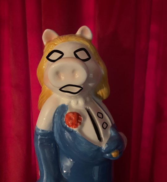 The official Miss Piggy coin bank in which the slot to insert coins is her cleavage, except her face has been replaced with Limbo's, and Limbo's eyes have also been added to her chest to turn the coin slot into a mouth.