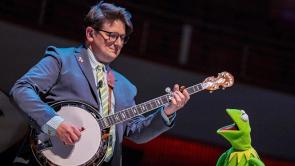 Lucas Ross playing banjo with a singing Kermit the Frog.